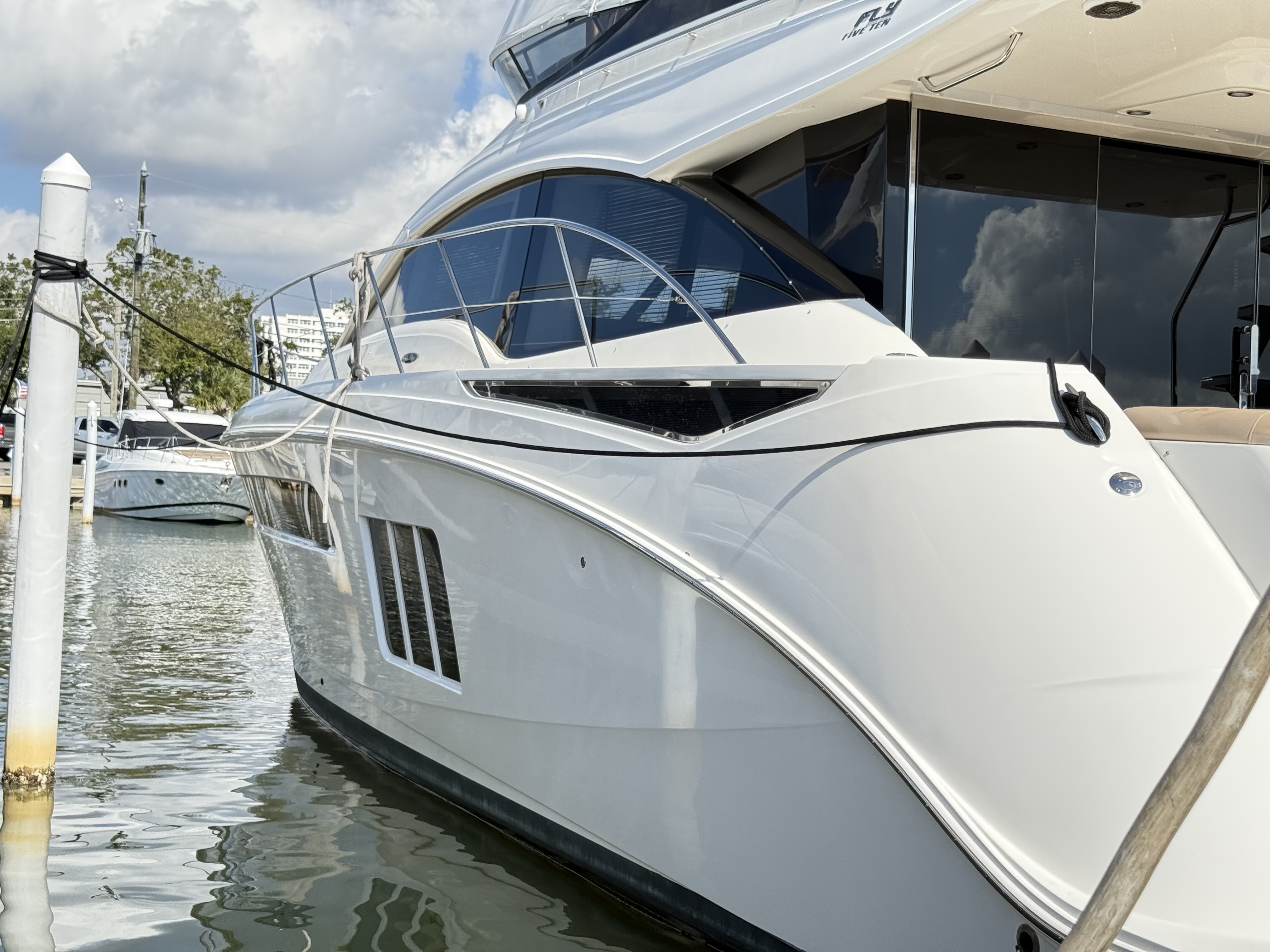 Motor yacht with polished white hull docked at Florida marina after marine detailing